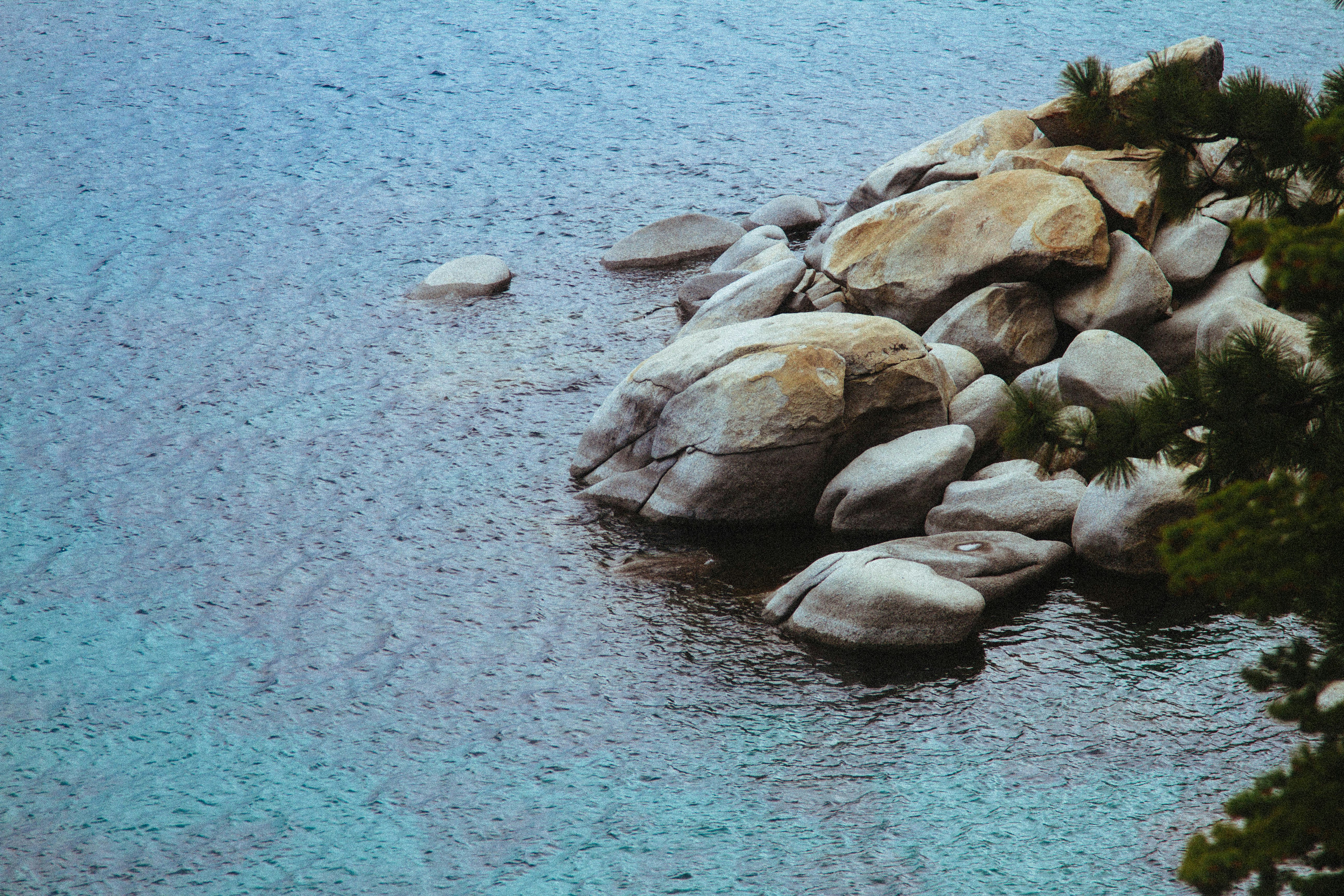 high angle photography of pile of stone beside body of water